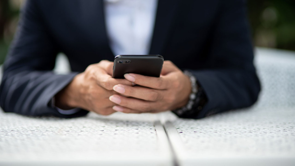 Person holding a phone wearing business attire