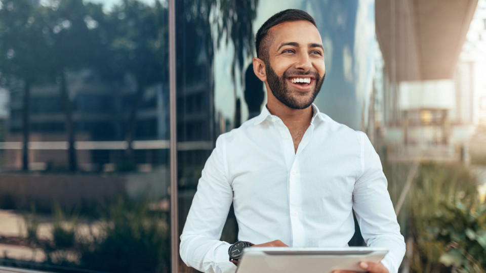 man smiling holding a clipboard