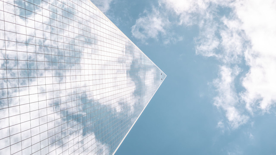 Tall building reflecting off of clouds